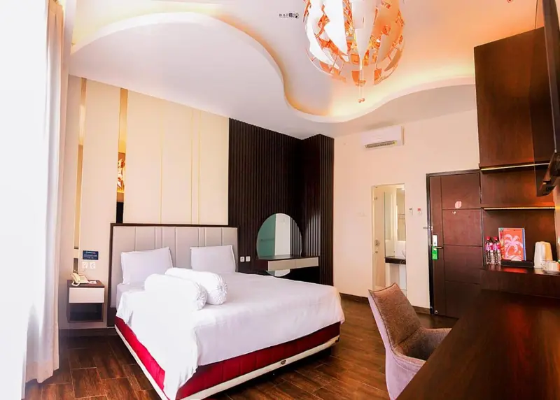 Une chambre lumineuse avec un grand lit et un coin salon.