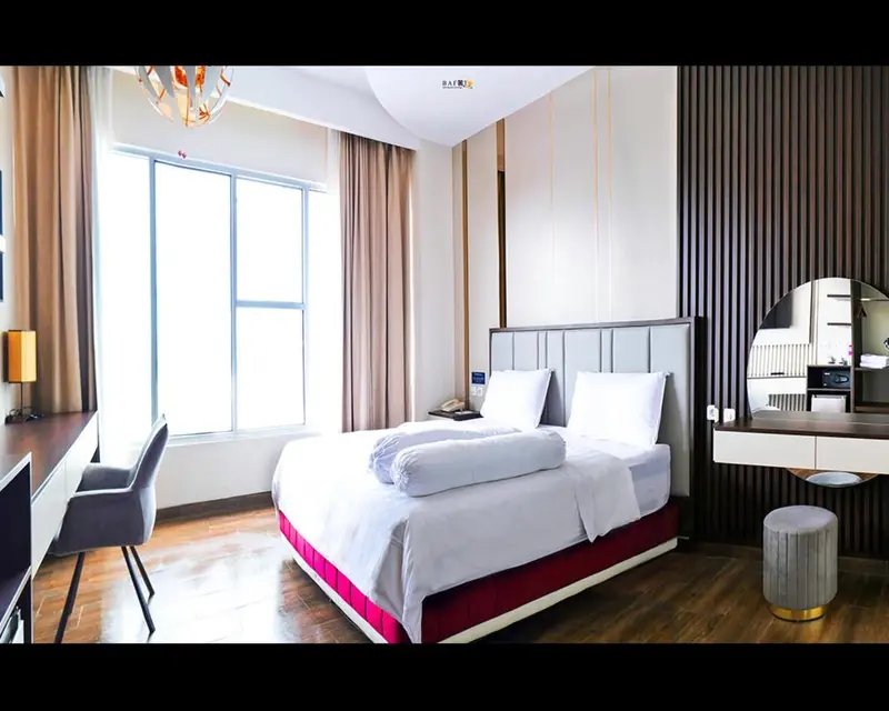 Une chambre d'hôtel lumineuse avec un grand lit et un espace bureau.