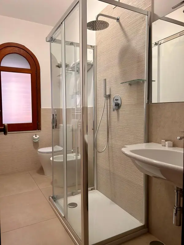Une salle de bain moderne avec douche à l'italienne et carrelage beige.