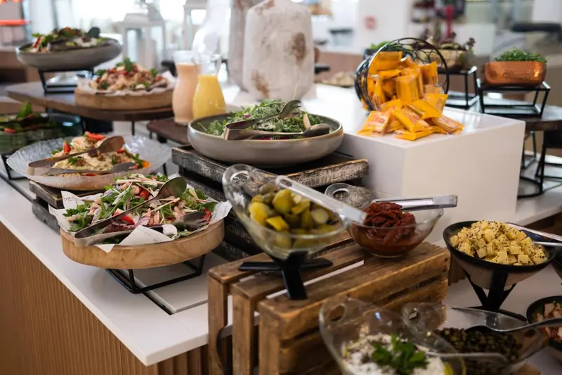 Un buffet propose une variété de salades, de crudités et de petites bouchées.