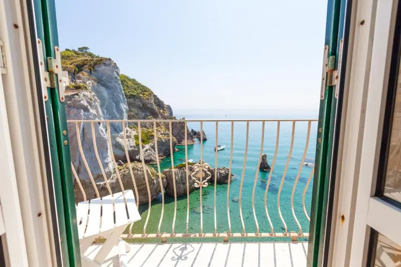 Vue sur une côte rocheuse et la mer depuis un balcon.