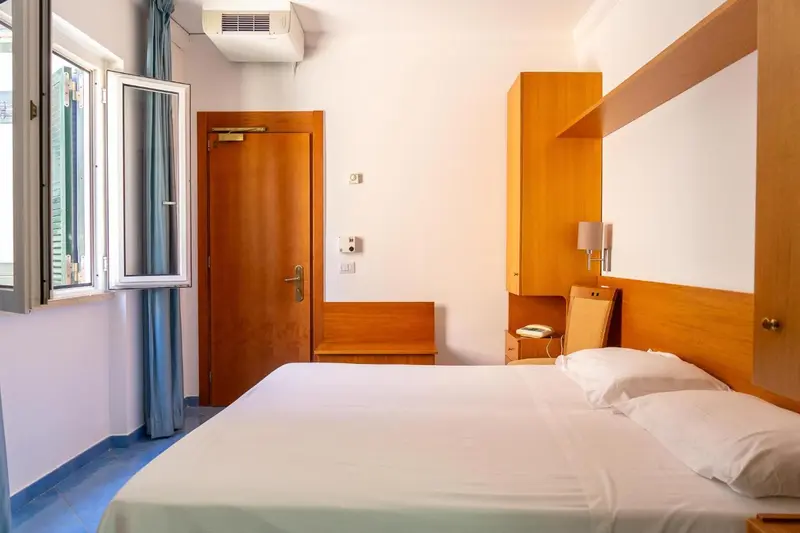 Une chambre lumineuse avec un lit simple et un meuble en bois.
