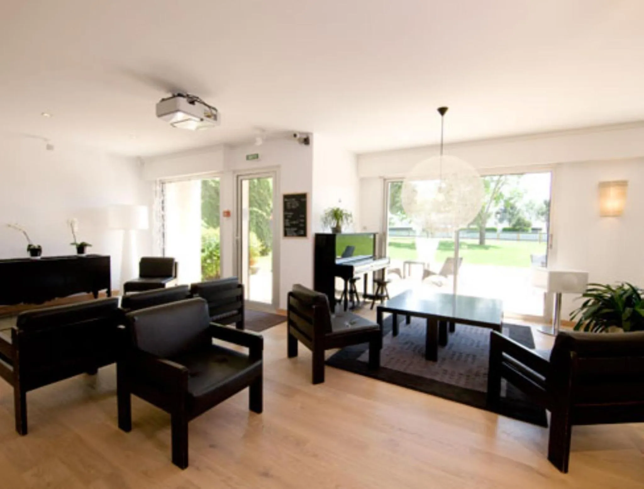 Espace de détente intérieur avec mobilier moderne et vue sur un jardin.