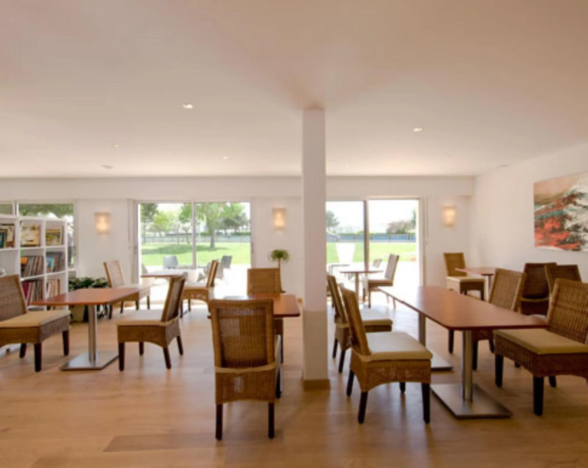 Une salle lumineuse avec des tables et des chaises en bois.