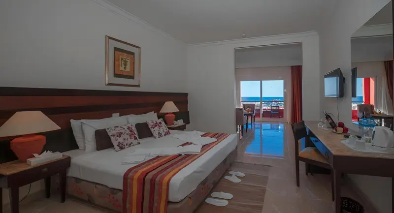 Une chambre lumineuse avec un grand lit et un accès à une terrasse.