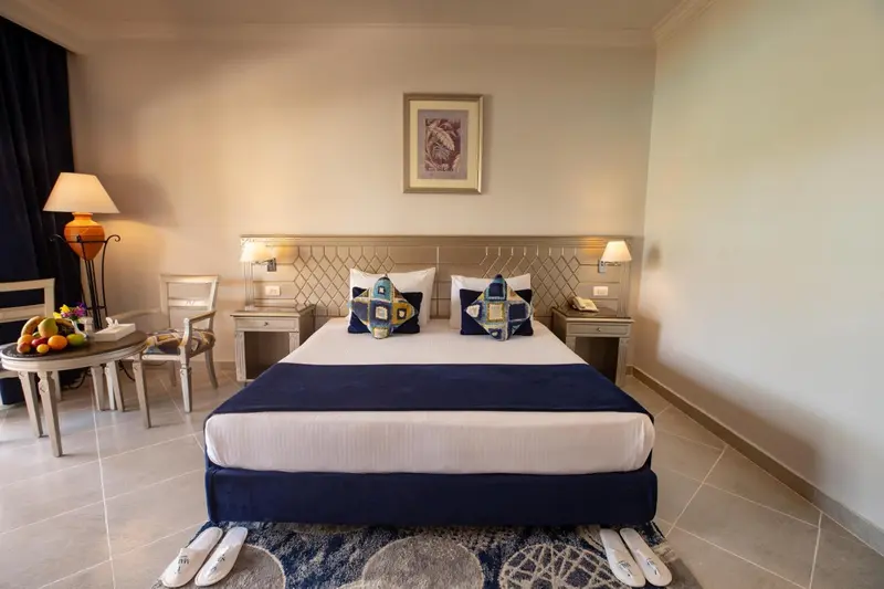 Une chambre lumineuse avec un grand lit et une table d'appoint.