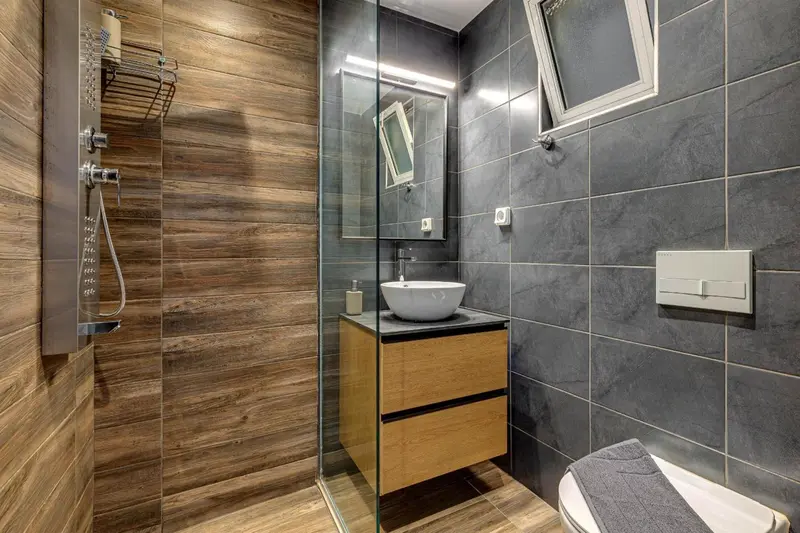 Une salle de bain moderne avec douche à l'italienne et lavabo sur meuble.