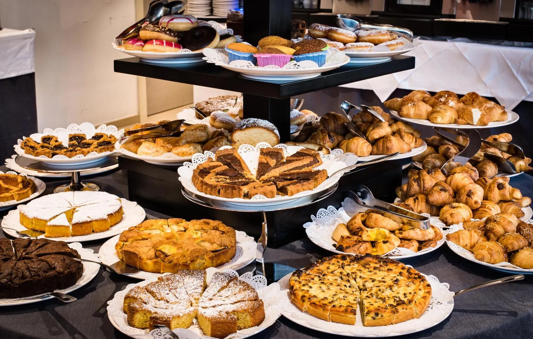 Un buffet propose une grande variété de pâtisseries et de viennoiseries.