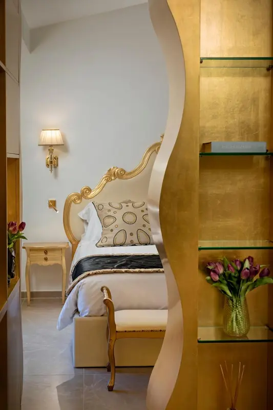 Une chambre à coucher avec un lit à baldaquin doré et des fleurs.