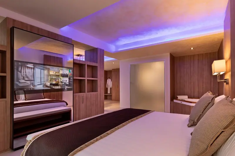Une chambre moderne avec un grand lit et un écran de télévision.