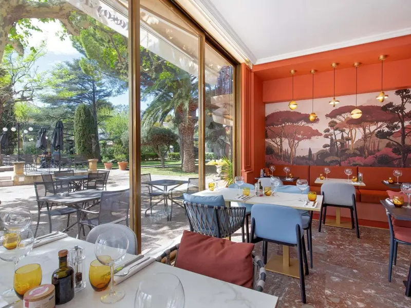 Une salle à manger lumineuse s'ouvre sur un jardin verdoyant.