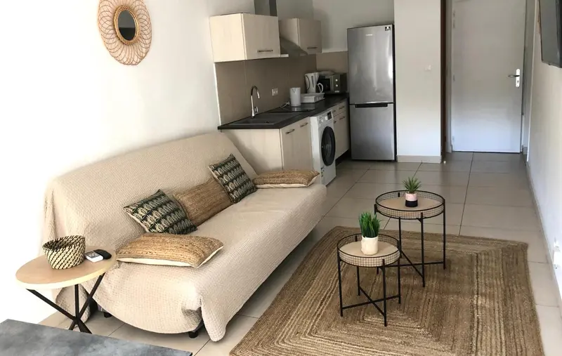 Espace de vie avec canapé et kitchenette.