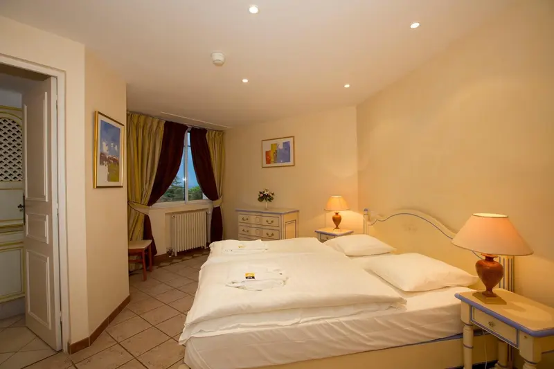 Une chambre lumineuse avec deux lits simples et une décoration murale.