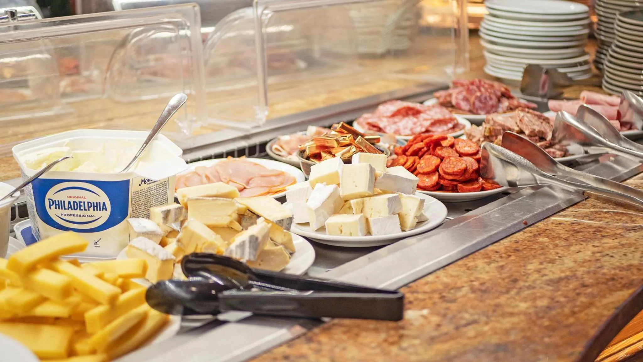 Présentation de charcuteries, fromages et accompagnements sur un buffet.