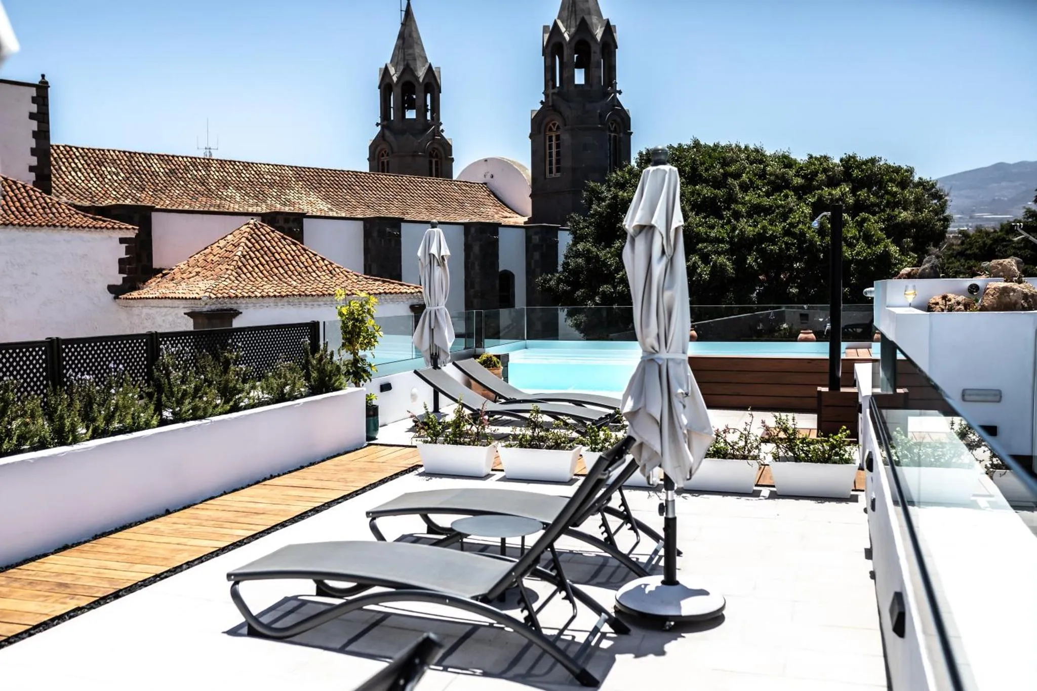 Terrasse avec transats et piscine au bord d'un bâtiment.