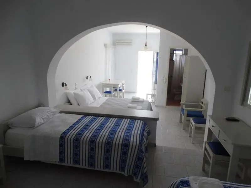 Une chambre lumineuse avec un lit et une table.