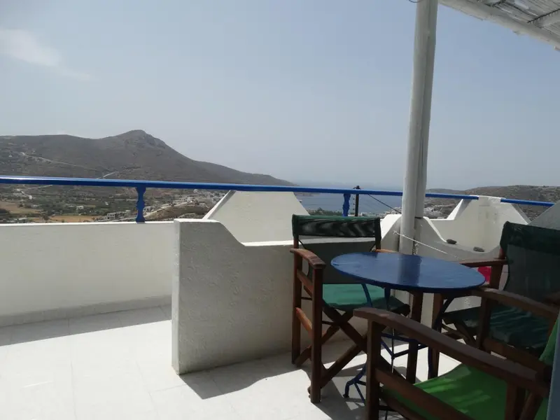 Terrasse avec mobilier de jardin et vue sur un paysage montagneux.