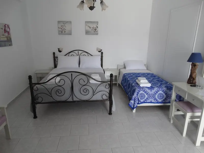 Une chambre lumineuse avec deux lits simples et une décoration sobre.