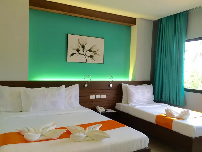 Une chambre lumineuse avec deux lits simples décorés de fleurs en papier.