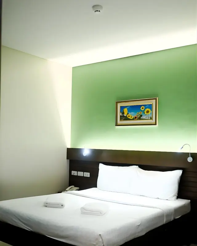 Une chambre lumineuse avec un lit simple et une décoration murale.
