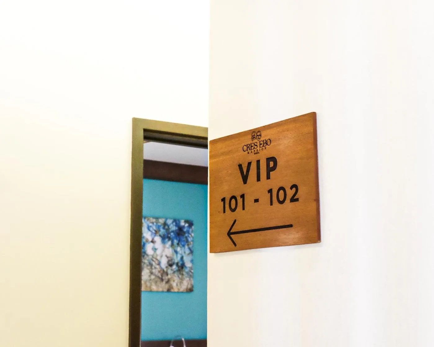 Panneau en bois indiquant les numéros de chambre VIP 101 et 102 avec une flèche.