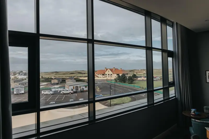 Vue sur un paysage côtier depuis une fenêtre.