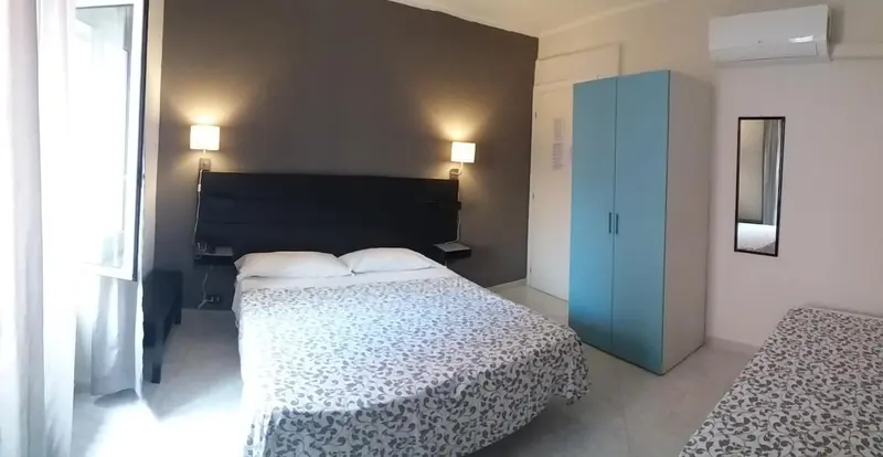 Une chambre avec un grand lit et une armoire bleue.