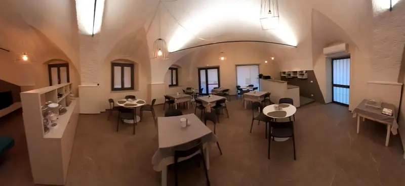 Une salle lumineuse avec des tables et des chaises disposées pour les repas.