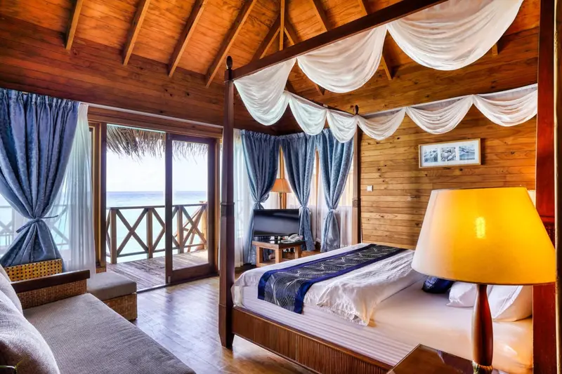 Une chambre lumineuse avec un grand lit et vue sur l'océan.