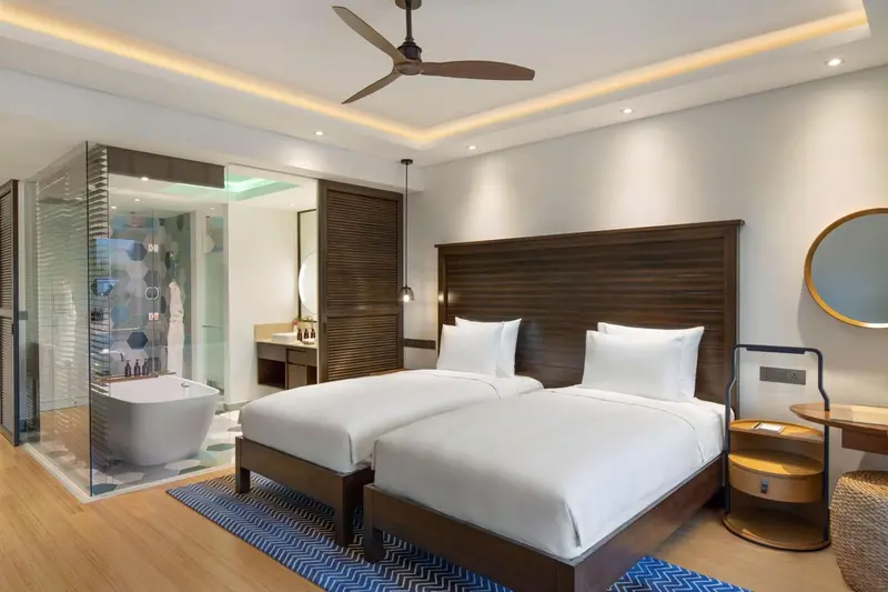 Une chambre lumineuse avec un grand lit et une salle de bain ouverte.