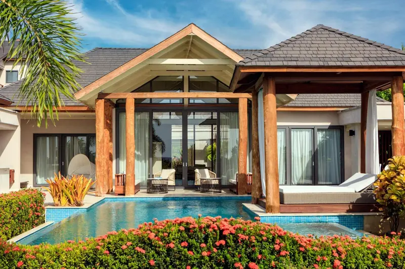 Une villa avec piscine privée et végétation luxuriante.