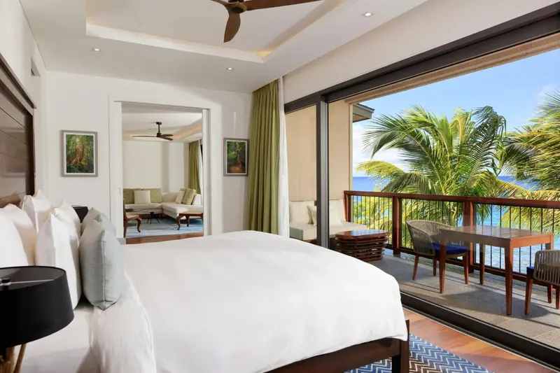 Une chambre lumineuse s'ouvre sur une terrasse avec vue sur la mer.