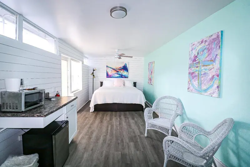 Une chambre lumineuse avec un lit blanc et une décoration colorée.