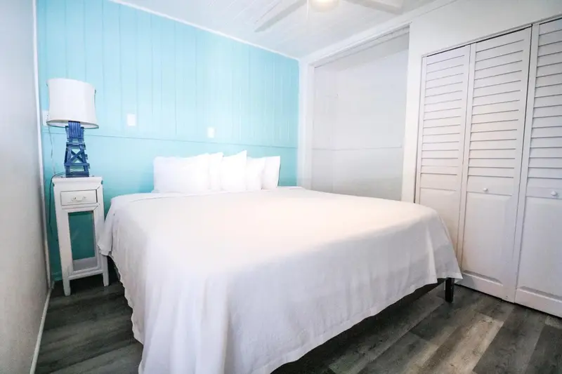 Une chambre lumineuse avec un grand lit recouvert de draps blancs.