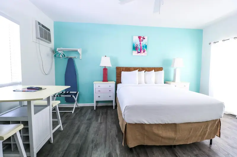 Une chambre lumineuse avec un lit double et un bureau.