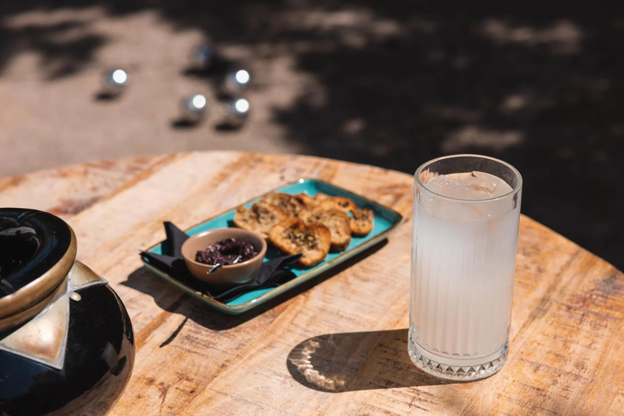 Une table en bois présente une assiette de nourriture et un verre d'eau.