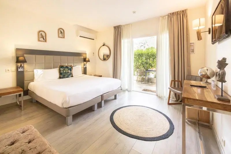 Une chambre lumineuse avec un grand lit et un accès à une terrasse.