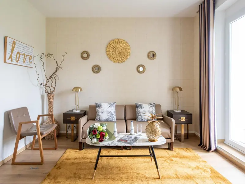 Un salon chaleureux avec un canapé, des fauteuils et une table basse.