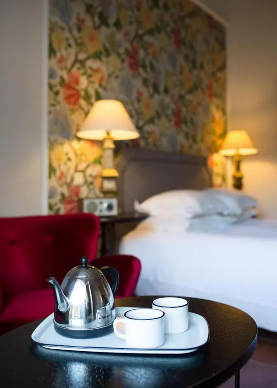 Une chambre d'hôtel avec un lit fait et une table de chevet.