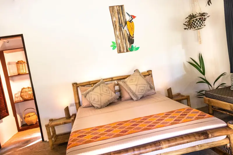 Une chambre avec un lit recouvert d'une courtepointe colorée et décorée de coussins.