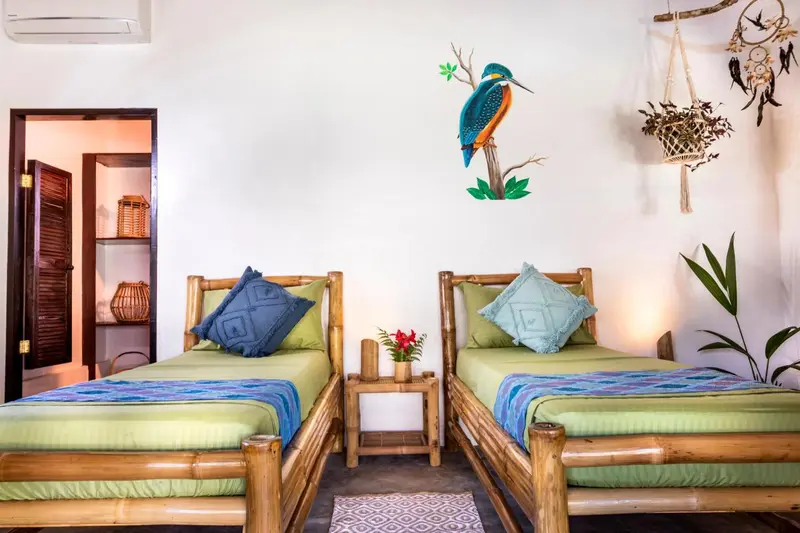 Une chambre lumineuse avec deux lits simples et une décoration murale.