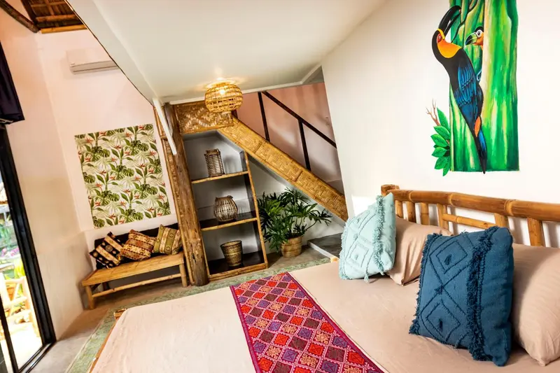 Chambre décorée avec un escalier en bois menant à une mezzanine.