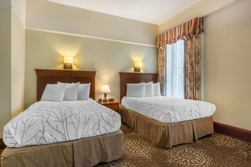 Deux lits simples dans une chambre d'hôtel lumineuse.