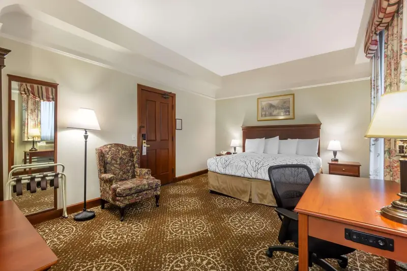 Une chambre d'hôtel lumineuse avec un lit et un coin bureau.