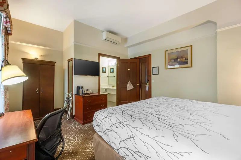 Une chambre lumineuse avec un grand lit et un bureau.