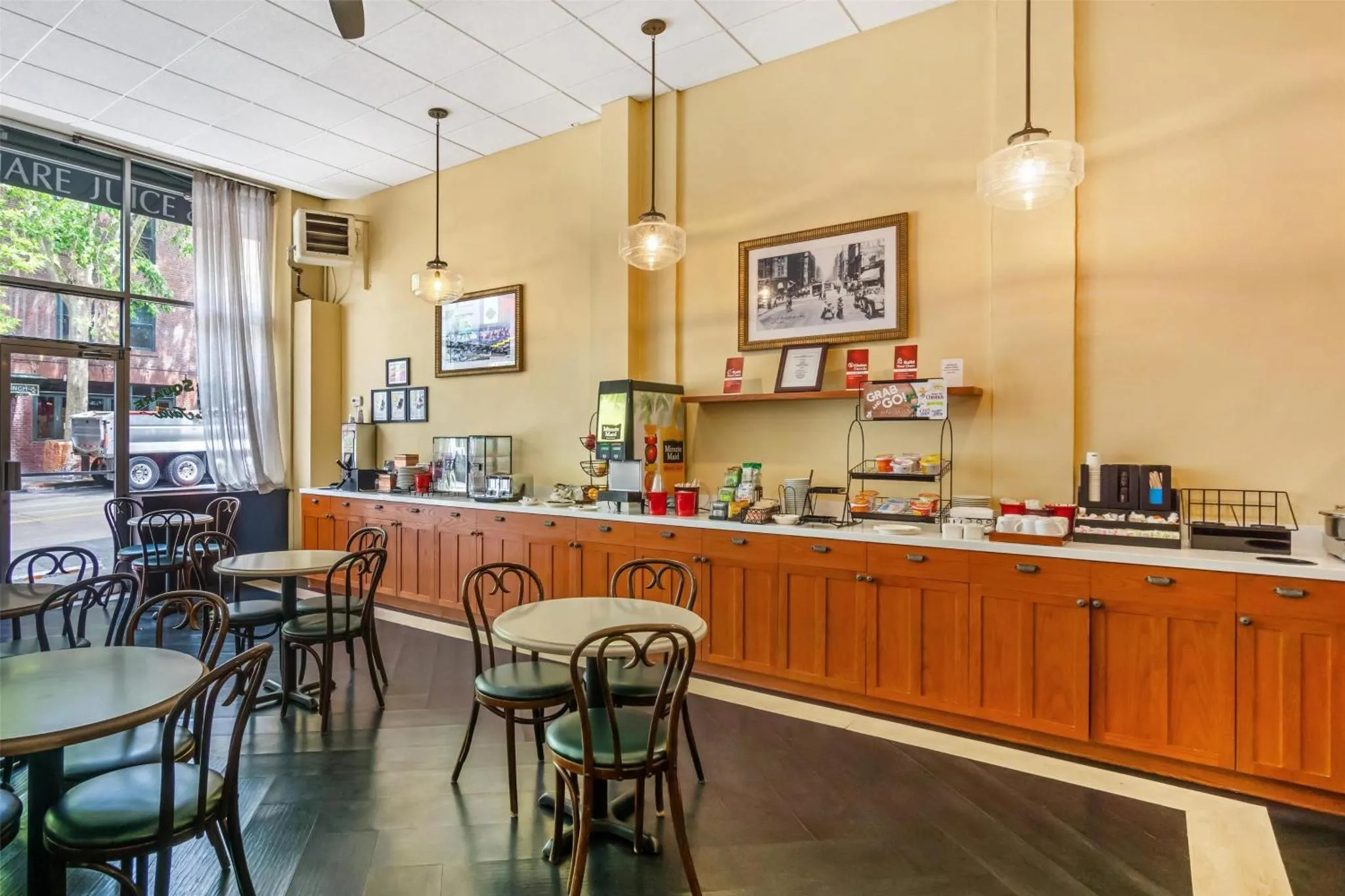 Une salle lumineuse avec des tables et des chaises près d'un comptoir de buffet.
