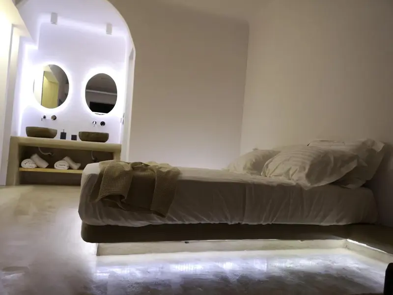Une chambre lumineuse avec un lit et un meuble vasque.