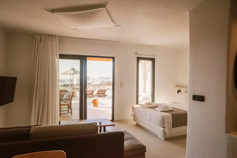 Une chambre lumineuse s'ouvre sur une terrasse avec vue sur la mer.