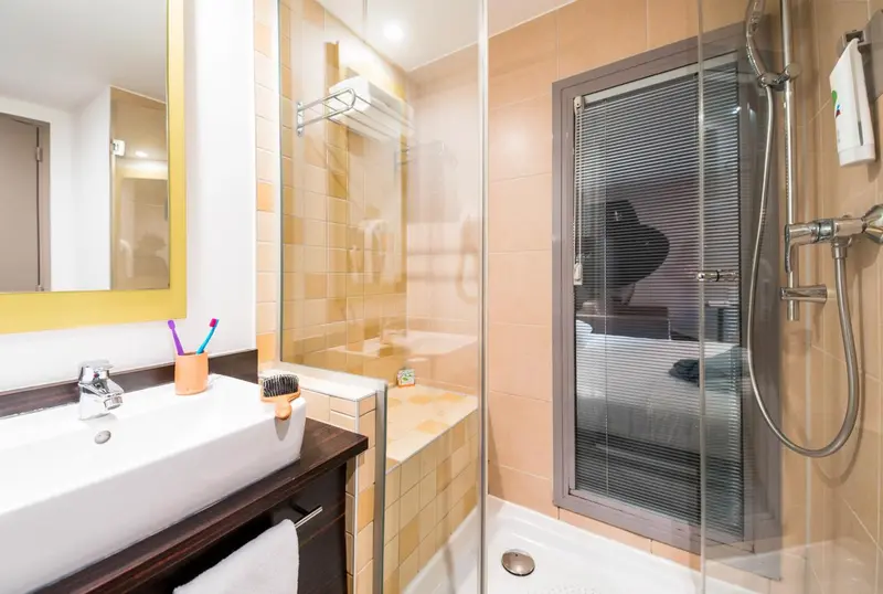 Une salle de bain moderne avec douche vitrée et lavabo.