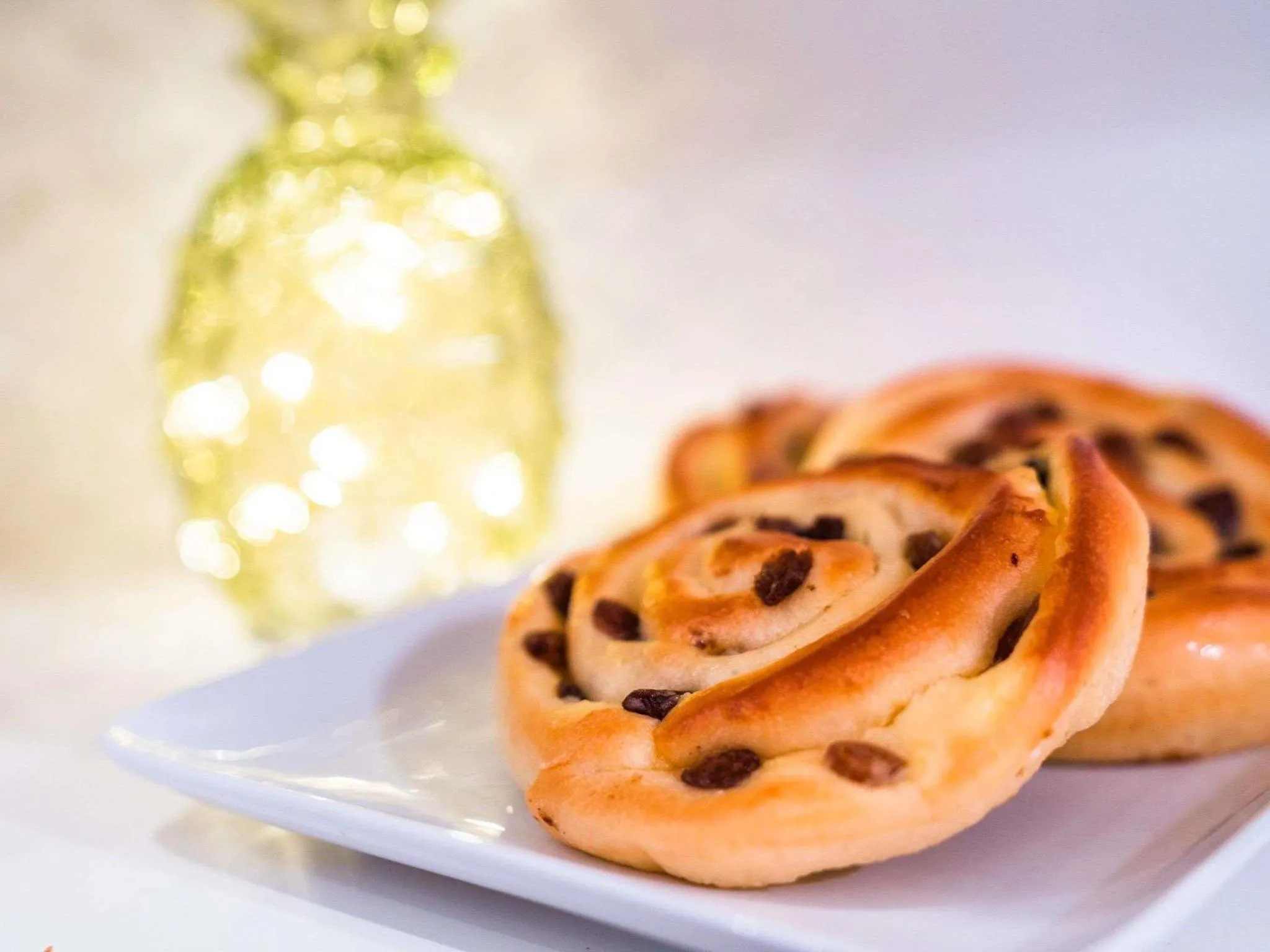 Des viennoiseries au chocolat et aux raisins secs sont présentées sur une assiette blanche.